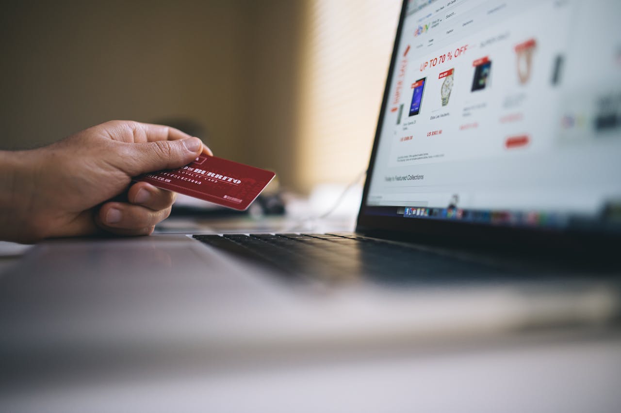home-img Person holding a credit card while shopping online on a laptop, indicating ecommerce transactions.